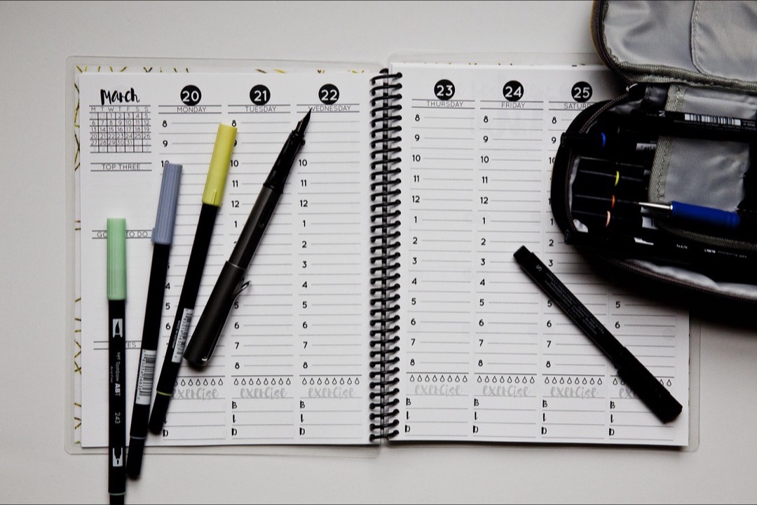 An open planner with colorful tabs and stickers on a desk