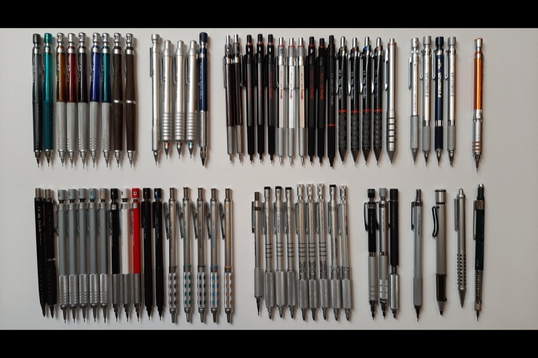 An assortment of mechanical pencils laid out on a desk surface