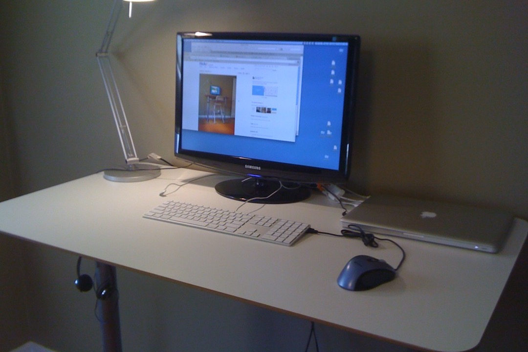 A sit-stand electric standing desk in a modern office environment