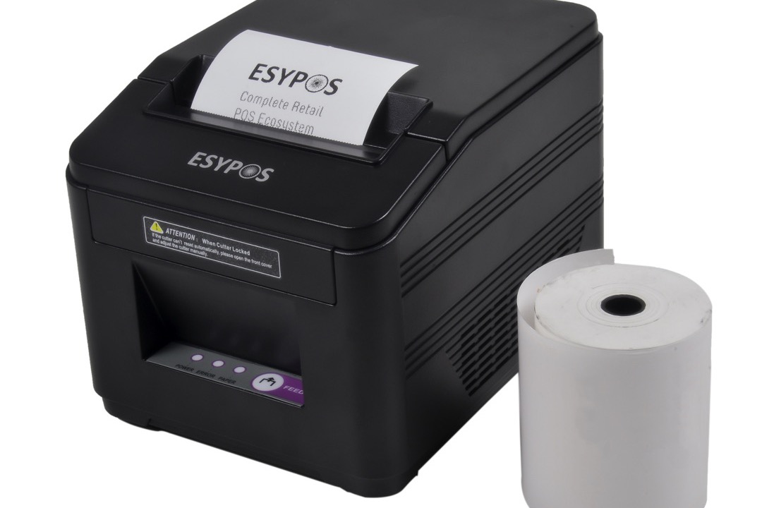 A thermal label printer on an office desk printing a shipping label