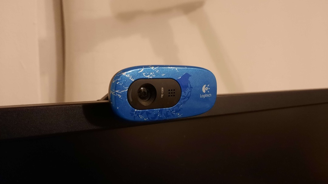 A Logitech HD webcam clipped to the top edge of a computer monitor