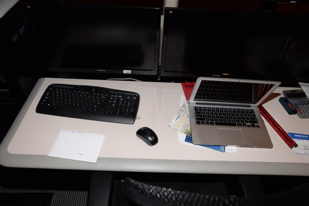 A clean, light home-office workstation with a laptop, external monitors, keyboard, and mouse on a light-colored desk